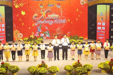 Phó Bí thư Thường trực Tỉnh ủy, Chủ tịch Hội đồng nhân dân tỉnh Hậu Giang Trần Văn Huyến (bên trái) và Phó Giáo sư, tiến sĩ Nguyễn Quốc Dũng, Giám đốc Học viện Chính trị khu vực II, trao quà cho các cháu.