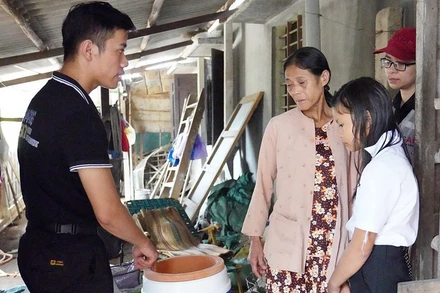 Nhân viên USAID (trái) hỗ trợ người khuyết tật bị ảnh hưởng bởi lũ lụt ở Việt Nam. (Ảnh: USAID)