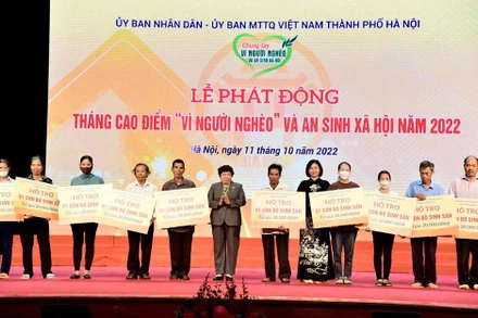 Trao trao kinh phí hỗ trợ xây nhà đại đoàn kết và phương tiện, công cụ sản xuất tặng các hộ nghèo. (Ảnh: Viết Thành)