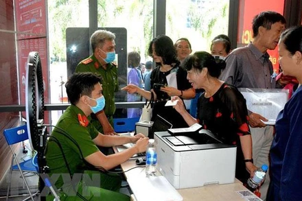 Công an làm căn cước công dân gắn chíp cho người dân tại điểm dịch vụ công trực tuyến. (Ảnh: TTXVN)