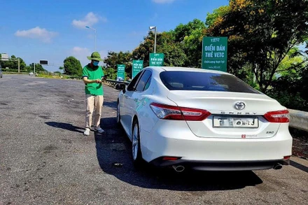 Nhân viên VETC hướng dẫn khách hàng dán thẻ ETC và nạp tiền vào tài khoản.