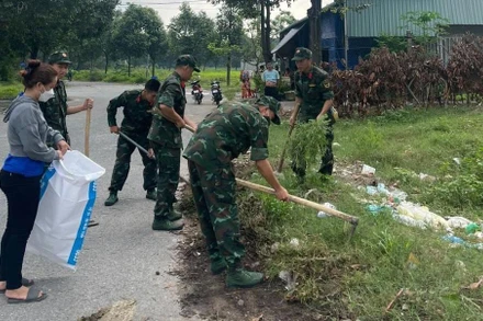 Bộ đội giúp dân tổng vệ sinh môi trường để phòng, chống dịch sốt xuất huyết ở Bình Dương. 