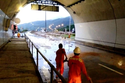 Lực lượng quản lý hầm Hải Vân nỗ lực suốt đêm dọn đất cát, bùn đá sau khi lũ quét. (Ảnh: ĐN)