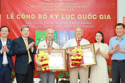 Thầy thuốc Ưu tú Nguyễn Đức Đoàn (thứ ba từ trái sang) và bác sĩ Nguyễn Hữu Trọng (thứ tư từ trái sang) nhận chứng nhận từ đại diện Tổ chức kỷ lục Việt Nam.