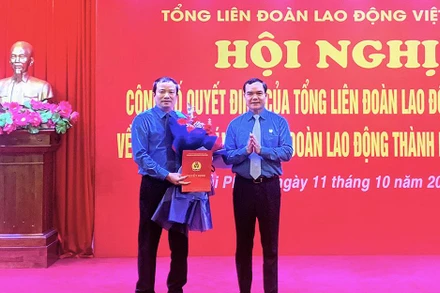 Chủ tịch Tổng Liên đoàn Lao động Việt Nam Nguyễn Đình Khang trao Quyết định và tặng hoa chúc mừng tân Chủ tịch Liên đoàn Lao động thành phố Hải Phòng Nguyễn Anh Tuân. 