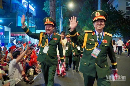 Người dân chào đón các đại biểu Anh hùng Lực lượng vũ trang nhân dân về sự Đại lễ. (Ảnh: MINH TÂM)
