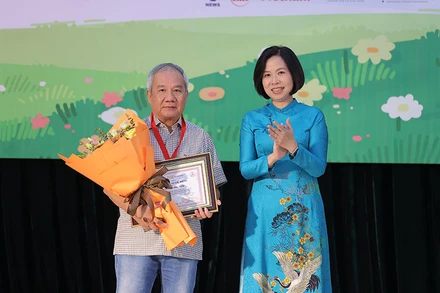 Tổng Giám đốc Thông tấn xã Việt Nam Vũ Việt Trang trao giải Hiệp sĩ Dế Mèn cho nhà văn Trần Đức Tiến. (Ảnh: Ban tổ chức)