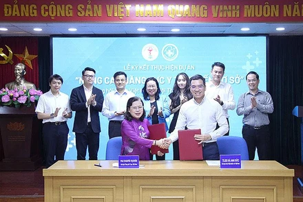 Chủ tịch Hội Thầy thuốc trẻ Việt Nam Hà Anh Đức và Chủ tịch Tổng hội Y học Việt Nam Nguyễn Thị Xuyên bàn giao biên bản ký kết chương trình phối hợp.