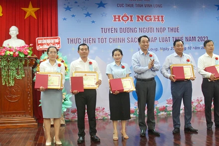 Chủ tịch Ủy ban nhân dân tỉnh Vĩnh Long Lữ Quang Ngời trao Bằng khen cho người nộp thuế tiêu biểu. 