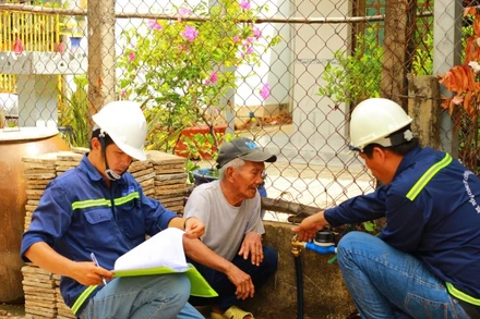 Nhân viên Xí nghiệp cấp nước Cần Giờ gắn đồng hồ nước cho người dân xã Tam Thôn Hiệp, huyện Cần Giờ. (Ảnh: QUÝ HIỀN)