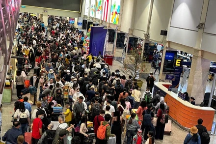 Từ 3 giờ 30 phút sáng 23/1, hành khách xếp hàng đông nghịt làm thủ tục bay tại sân bay Tân Sơn Nhất. (Ảnh: QUÝ HIỀN)