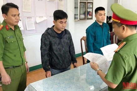 Công an đọc lệnh bắt tạm giam đối tượng Huỳnh Tấn Anh Điệp (người mặc áo khoác màu đen). 