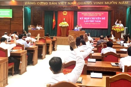 Các đại biểu Hội đồng nhân dân tỉnh Đắk Lắk biểu quyết thông qua các nghị quyết của kỳ họp.