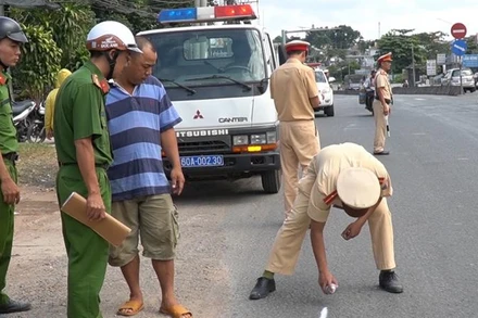 Khám nghiệm hiện trường vụ xe ô-tô làm rơi học sinh xuống đường trong quá trình lưu thông tại Đồng Nai năm 2019.