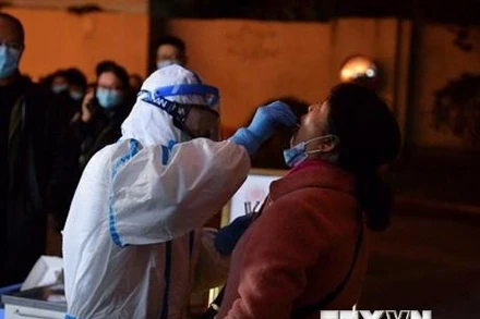 Nhân viên y tế lấy mẫu xét nghiệm Covid-19 cho người dân tại Thành Đô, thủ phủ tỉnh Tứ Xuyên, Trung Quốc. (Ảnh: AFP/TTXVN)