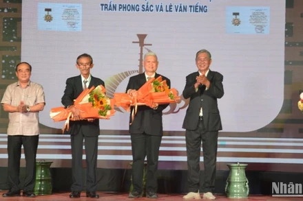 Đại diện gia đình nghệ nhân Trần Phong Sắc và nghệ nhân Lê Văn Tiếng nhận quyết định truy tặng danh hiệu Nghệ nhân dân gian.