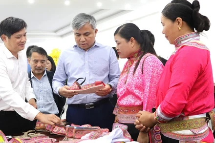 Đồng chí Lò Văn Tiến (thứ ba từ phải sang), Phó Chủ tịch Hội đồng nhân dân tỉnh Điện Biên, tham quan gian trưng bày giày thêu của đồng bào dân tộc Xạ Phang thôn Tả Sìn Thàng, xã Tả Sìn Thàng, huyện Tủa Chùa.