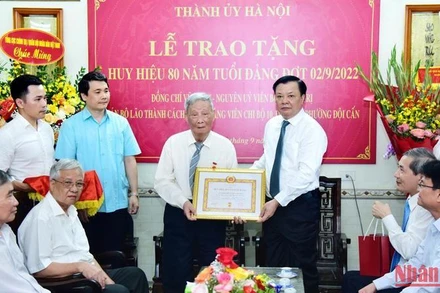 Bí thư Thành ủy Hà Nội trao Huy hiệu 80 năm tuổi Đảng tặng đồng chí Vũ Oanh.