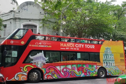 Du khách quốc tế tham quan Hà Nội bằng xe buýt 2 tầng (Ảnh: T.LINH)