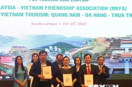 Đại diện Trung tâm Xúc tiến du lịch 3 tỉnh thành Quảng Nam-Đà Nẵng-Thừa Thiên Huế và Chủ tịch Hội Hữu nghị Malaysia–Việt Nam (giữa) ký kết biên bản ghi nhớ hợp tác truyền thông và quảng bá du lịch. (Ảnh: TTXVN)