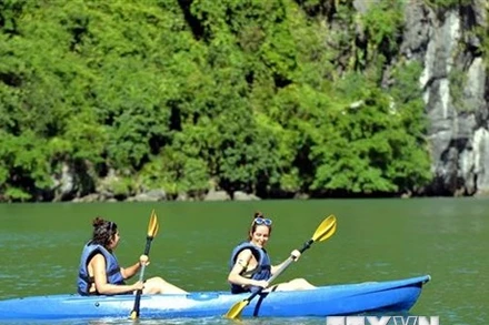 Du khách trải nghiệm chèo thuyền kayak, thuyền tay trên Vịnh Hạ Long. (Ảnh: Thanh Vân/TTXVN)