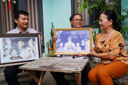 Ông Hồ Ngọc Biên (ở giữa) cùng vợ và người con trai thứ 2 bên những tấm hình vinh dự được chụp chung với Bác Hồ.