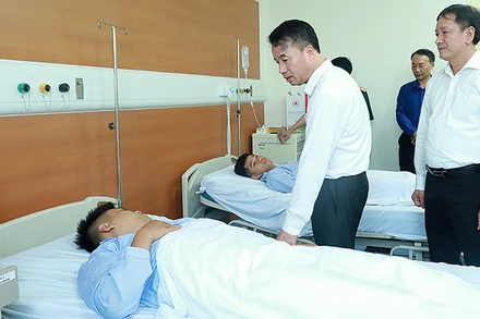 Tổng Giám đốc Bảo hiểm xã hội Việt Nam Nguyễn Thế Mạnh, Giám đốc Bảo hiểm xã hội Hà Nội thăm hỏi nạn nhân vụ cháy. (Ảnh: Khánh Duy)