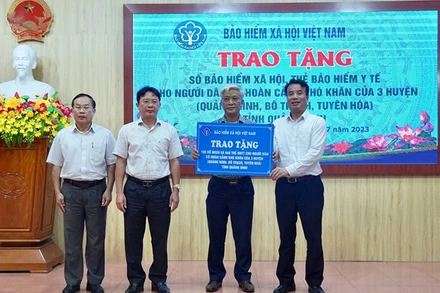 Tổng Giám đốc Bảo hiểm xã hội Việt Nam Nguyễn Thế Mạnh trao tặng sổ bảo hiểm xã hội, thẻ bảo hiểm y tế cho các địa phương của tỉnh Quảng Bình, tháng 7/2023. (Ảnh: TÂM TRUNG)