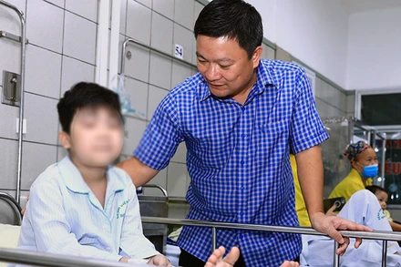 Đại diện Cục Bảo trợ xã hội thăm, động viên bệnh nhi là nạn nhân trong vụ cháy chung cư mini tại Khương Hạ đang điều trị tại Bệnh viện Bạch Mai. (Ảnh: Molisa)