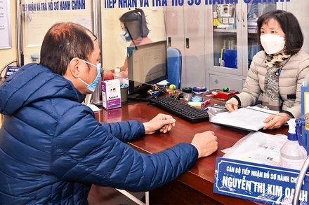 Cán bộ tại Bộ phận “một cửa” UBND phường Nguyễn Du, quận Hai Bà Trưng, giải quyết thủ tục hành chính cho người dân. (Ảnh: Đăng Duy) 