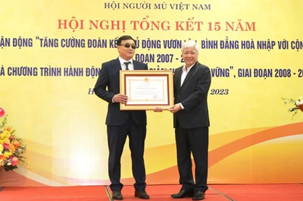 Đồng chí Đỗ Văn Chiến trao Huân chương Lao động hạng Ba tặng ông Phạm Xuân Trường, Ủy viên Ban Thường vụ Hội Người mù Việt Nam, với những đóng góp vì người mù. (Ảnh: mattran.org.vn)