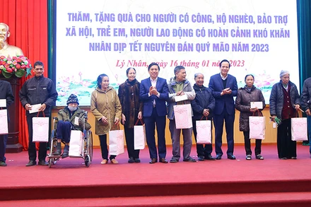 Bộ trưởng Đào Ngọc Dung, lãnh đạo tỉnh Hà Nam tặng quà gia đình chính sách tại huyện Lý Nhân. (Ảnh: Molisa)