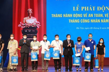 Tặng quà công nhân lao động bị tai nạn lao động tại lễ phát động Tháng hành động về an toàn, vệ sinh lao động và Tháng Công nhân năm 2022. (Ảnh: nhandan.vn)