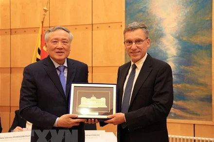 Chánh án Tòa án Nhân dân Tối cao Nguyễn Hòa Bình (trái) tặng quà lưu niệm cho ông Christian Coquoz, Chánh án Tòa án bang Geneva. (Ảnh: TTXVN)