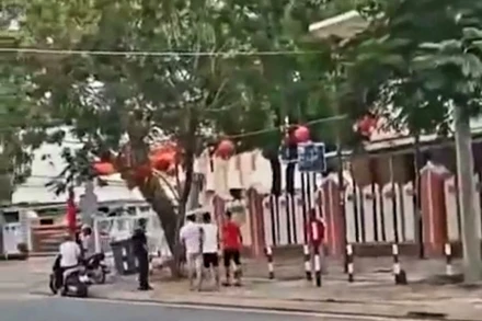 Nhóm thanh niên cầm hung khí vào trụ sở Ủy ban nhân dân xã Hàm Ninh là để giao nộp cho Công an. (Ảnh cắt từ clip)