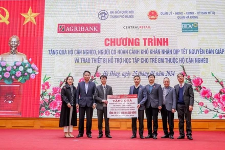Đồng chí Phạm Đức Ấn trao tặng quà của Agribank hỗ trợ hộ cận nghèo, đối tượng chính sách quận Hà Đông (Hà Nội).