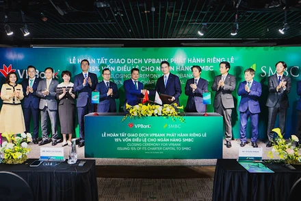 Đại diện lãnh đạo hai ngân hàng trao đổi văn kiện chứng nhận hoàn tất thương vụ phát hành cổ phiếu riêng lẻ.