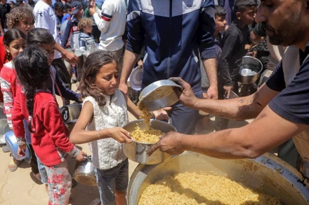 Trẻ em Palestine nhận thực phẩm viện trợ ở Dải Gaza. (Ảnh TÂN HOA XÃ)