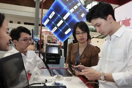 Hướng dẫn khách hàng sử dụng ngân hàng online tại Diễn đàn Chuyển đổi số ngành Ngân hàng năm 2024. (Ảnh TTXVN)