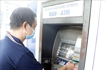 Người dân sử dụng thẻ nội địa tại máy rút tiền tự động của BIDV. (Minh họa: Trần Việt/TTXVN)