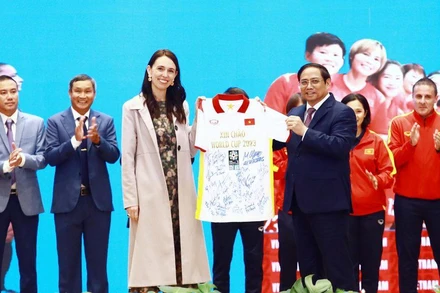 Thủ tướng Phạm Minh Chính trao áo đấu của đội tuyển bóng đá nữ Việt Nam tặng Thủ tướng New Zealand. (Ảnh: VFF)