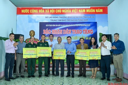 Tổng Biên tập Báo Nhân Dân Lê Quốc Minh cùng các đại biểu và nhà tài trợ trao tặng bàn bóng bàn cho các đơn vị. 