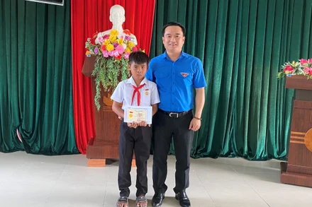 Anh Đỗ Duy Nam trao huy hiệu "Tuổi trẻ dũng cảm" cho em Kpă Nguyên. 