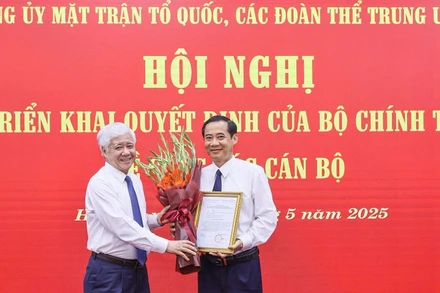 Đồng chí Đỗ Văn Chiến (bên trái) trao Quyết định, tặng hoa chúc mừng Phó Bí thư Đảng ủy Mặt trận Tổ quốc, các đoàn thể Trung ương nhiệm kỳ 2020-2025 Nguyễn Thái Học.