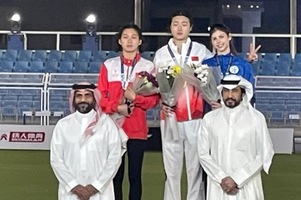 Mai Ngọc Ánh (bên trái, áo đỏ) trên bục nhận Huy chương. 