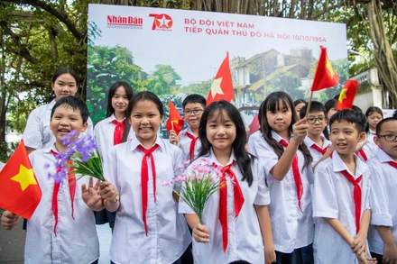 Các em học sinh Trường trung học cơ sở Hoàn Kiếm thích thú với cờ hoa tại sự kiện. 