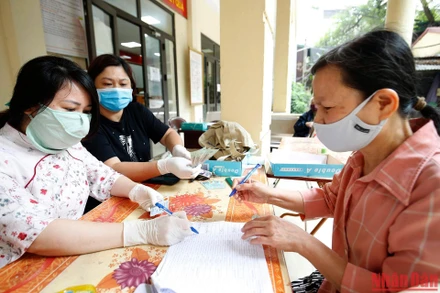 Người lao động nhận tiền hỗ trợ do ảnh hưởng vì dịch Covid-19. (Ảnh: Duy Linh)