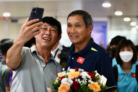 Người hâm mộ chụp hình cùng huấn luyện viên Mai Đức Chung. (Ảnh: VFF)