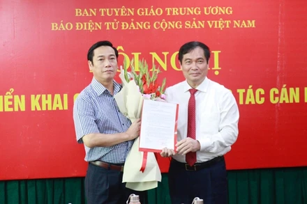 Phó Trưởng Ban Tuyên giáo Trung ương Phan Xuân Thủy trao Quyết định và tặng hoa chúc mừng đồng chí Nguyễn Công Dũng.