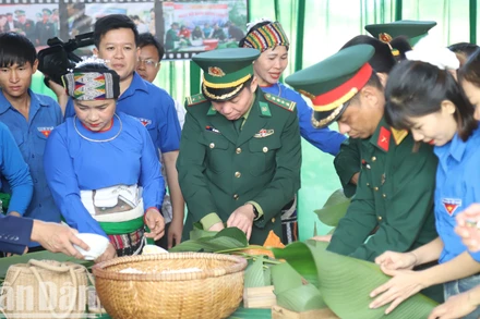 Đại tá Đỗ Quang Thấm, Bí thư Đảng ủy, Chính ủy Bộ đội Biên phòng tỉnh Đắk Lắk tham gia gói bánh chưng tại chương trình tặng nhân dân biên giới đón Tết.